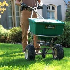 Professional fertilizer spreader applying nutrients to a lawn