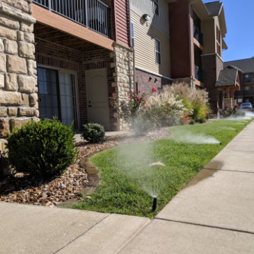 Sprinkler system watering a front yard lawn