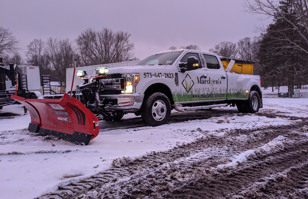 Snow plow truck clearing a residential driveway